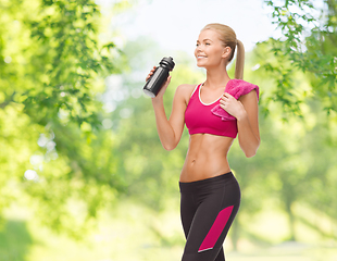 Image showing sporty woman drinking water from bottle