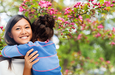 Image showing happy mother and daughter hugging over garden