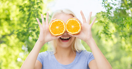 Image showing happy woman having fun covering eyes with orange