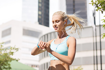 Image showing happy woman with fitness tracker and earphones