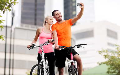 Image showing couple with bicycles taking selfie by smartphone