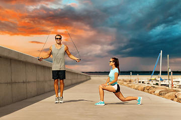 Image showing happy couple warming up on pier before training