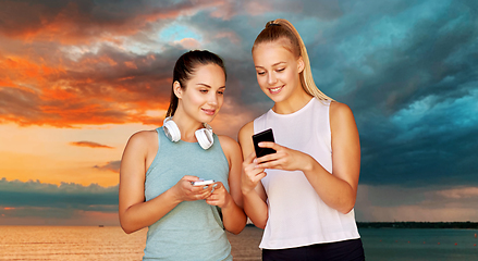 Image showing women or female friends with smartphones over sea