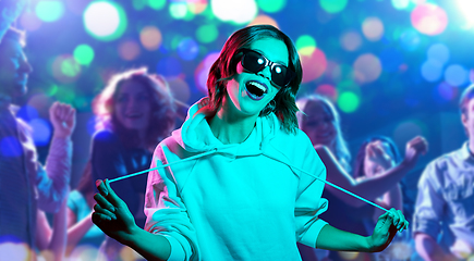 Image showing woman in hoodie and sunglasses at nightclub