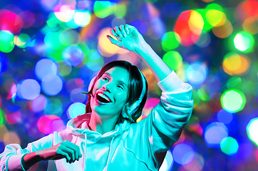 Image showing woman in headphones dancing over night lights