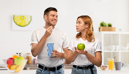 Image showing couple in white t-shirts with popcorn and apple