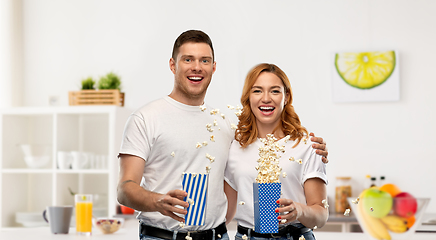 Image showing happy couple in white t-shirts eating popcorn