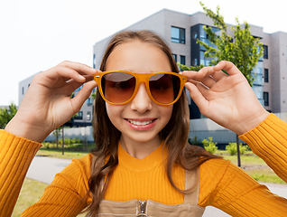 Image showing smiling teenage girl in sunglasses on city street