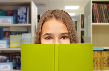 Image showing teenage student girl hiding over book at library