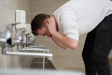 Image showing A Muslim takes ablution for prayer. Islamic religious rite