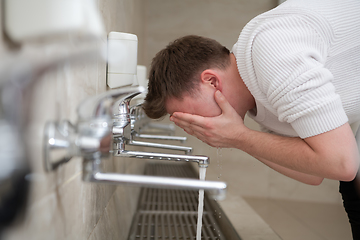 Image showing A Muslim takes ablution for prayer. Islamic religious rite