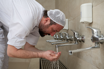 Image showing A Muslim takes ablution for prayer. Islamic religious rite