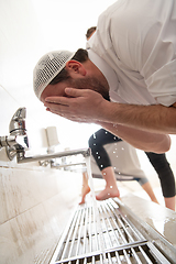 Image showing a group of Muslims take ablution for prayer. Islamic religious rite