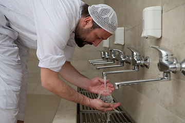 Image showing A Muslim takes ablution for prayer. Islamic religious rite