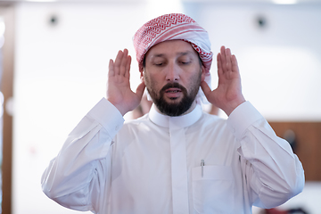 Image showing a Muslim begins to offer prayer by raising his hands in the air, a calm state in prayer.