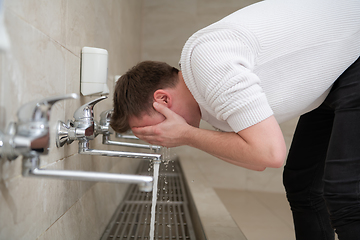 Image showing A Muslim takes ablution for prayer. Islamic religious rite