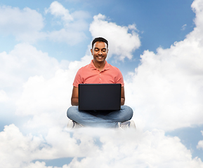 Image showing happy indian man with laptop computer in clouds