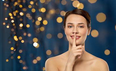 Image showing beautiful young woman holding finger on lips