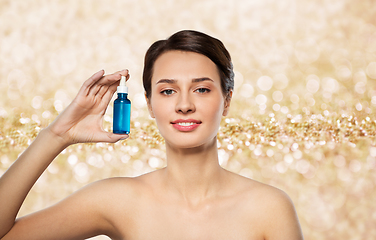 Image showing beautiful young woman with bottle of serum