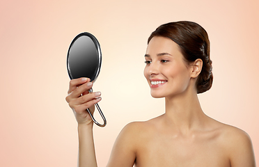 Image showing beautiful young woman looking to mirror