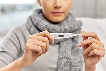 Image showing sick woman measuring temperature by thermometer