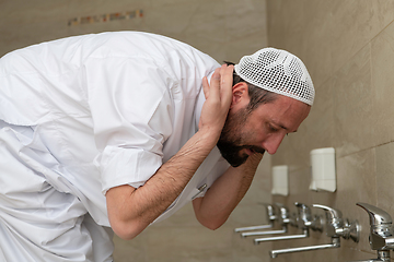 Image showing A Muslim takes ablution for prayer. Islamic religious rite