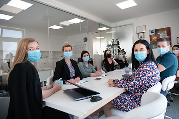 Image showing real business people on meeting wearing protective mask