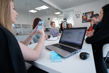 Image showing business woman as team leader on meeting checking phone messages