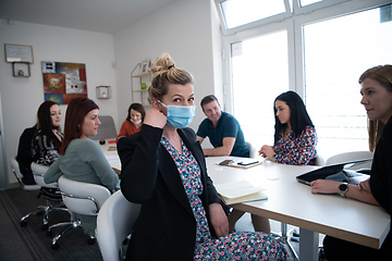 Image showing real business people on meeting wearing protective mask