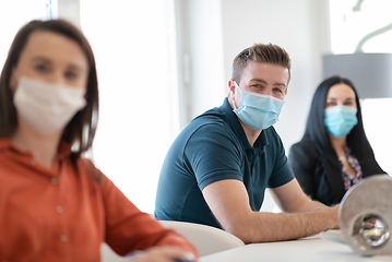 Image showing real business people on meeting wearing protective mask