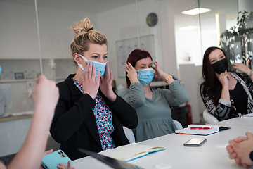 Image showing real business people on meeting wearing protective mask