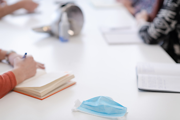 Image showing Closeup of protective medical face mask at desk on business meeting