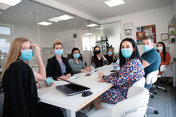 Image showing real business people on meeting wearing protective mask