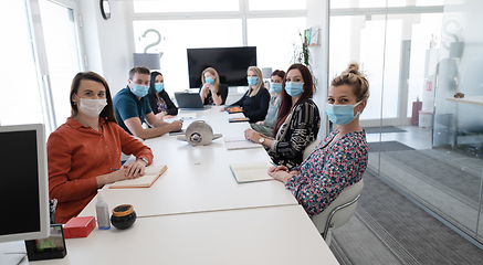 Image showing real business people on meeting wearing protective mask