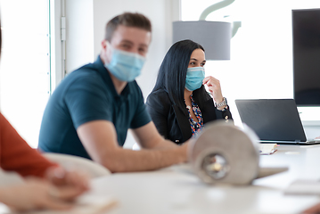 Image showing real business people on meeting wearing protective mask