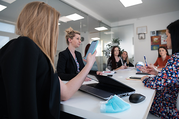 Image showing business woman as team leader on meeting checking phone messages