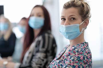 Image showing real business people on meeting wearing protective mask