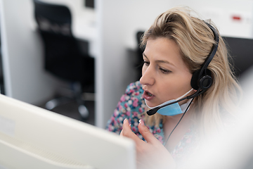 Image showing call center operator in medical mask