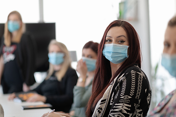 Image showing real business people on meeting wearing protective mask