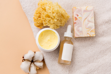 Image showing body butter, essential oil, sponge on bath towel