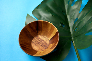 Image showing close up of wooden plate and monstera leaf