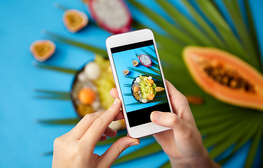 Image showing hands taking photo of exotic fruits on smartphone