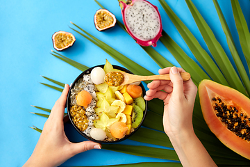 Image showing hands with mix of exotic fruits and wooden spoon