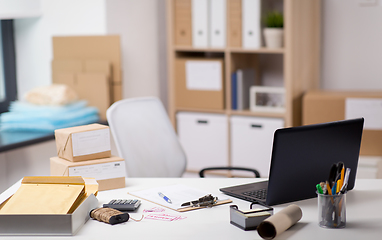 Image showing laptop and parcels on table at post office