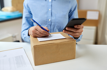 Image showing close up of woman filling postal form at office