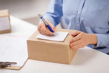 Image showing close up of woman filling postal form at office