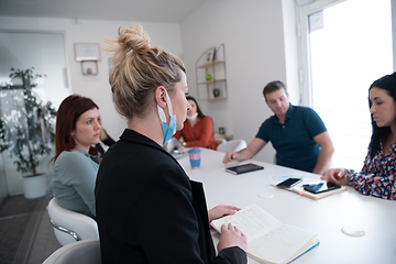 Image showing real business people on meeting wearing protective mask