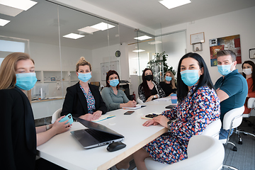 Image showing real business people on meeting wearing protective mask