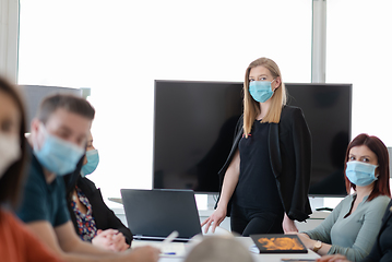 Image showing real business people on meeting wearing protective mask