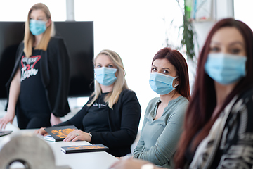 Image showing real business people on meeting wearing protective mask